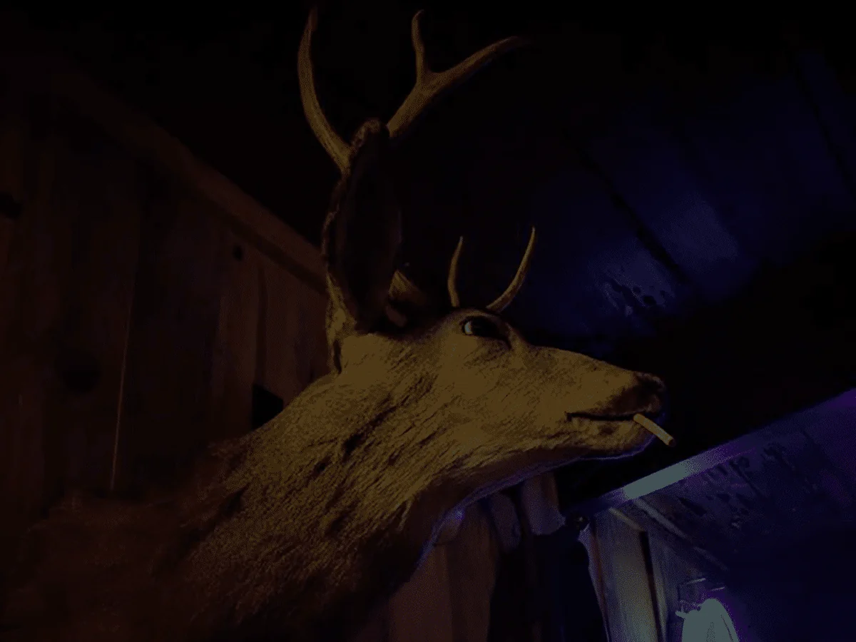 Jim, the saloon’s mounted buck, with a cigarette in his mouth, on the pine boards above the bar with blue neon behind him